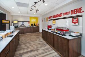 a kitchen with wooden cabinets and a counter top at Hampton Inn and Suites St. Cloud in Saint Cloud