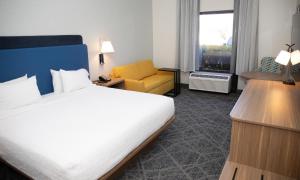 a hotel room with a bed and a yellow chair at Hampton Inn Shrewsbury in Shrewsbury +29 photos