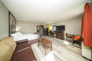 a hotel room with a bed and a desk at Super 8 by Wyndham Kingston in Kingston