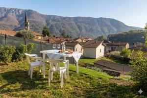 a white table and chairs with a view of a village at Casa Silvia Natura Relax, Sport & Family in Omegna