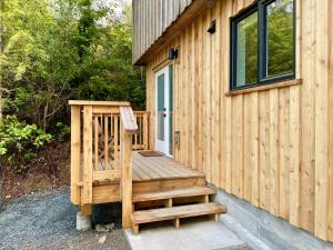 a wooden bench sitting on the side of a house at Tofino Trailhead in Tofino