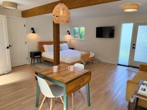 a bedroom with a bed and a table and chairs at Tofino Trailhead in Tofino