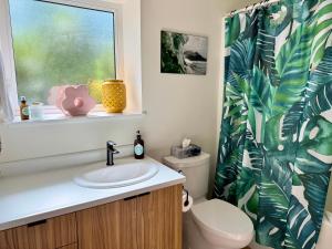 a bathroom with a sink and a toilet and a window at Tofino Trailhead in Tofino