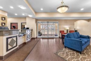 a living room with a blue couch and a table at Comfort Inn Ogden near Event Center in Ogden