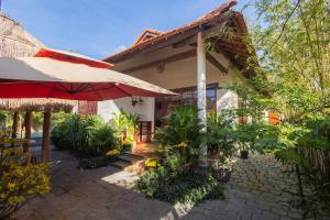 a patio with an umbrella and a house at Banyan Villa Nha Trang in Nha Trang