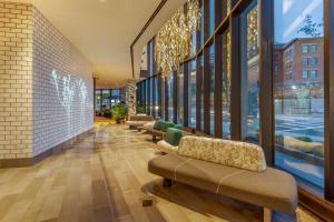 a lobby with couches and windows in a building at Cambria Hotel Boston Downtown - Seaport in Boston