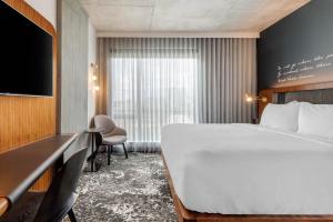 a hotel room with a large bed and a tv at Cambria Hotel Boston Downtown - Seaport in Boston +118 photos