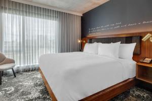 a bedroom with a large bed and a large window at Cambria Hotel Boston Downtown - Seaport in Boston