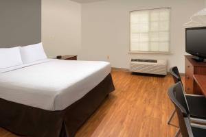 a bedroom with a bed and a flat screen tv at WoodSpring Suites Killeen in Killeen