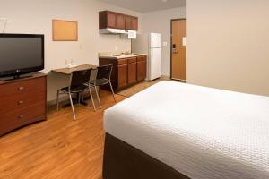 a room with a bed and a kitchen with a television at WoodSpring Suites Killeen in Killeen