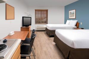 a hotel room with two beds and a desk at WoodSpring Suites Killeen in Killeen
