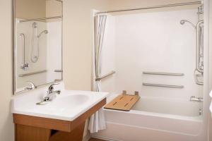 a bathroom with a sink and a tub and a shower at WoodSpring Suites Killeen in Killeen +9 photos