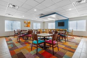 a dining room with tables and chairs on a colorful rug at Comfort Inn & Suites Mt Laurel-Philadelphia in Mount Laurel