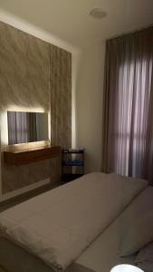 a bedroom with a large bed and a window at Al Azaiba apartment in Muscat