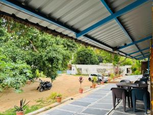 awning over a patio with tables and chairs at Junglee tree stays in Hampi