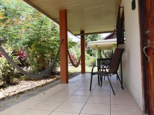 a porch with a hammock on a house at Cahuita Lodge in Cahuita