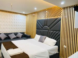 a bedroom with a large bed and a couch at The Warmwood Studio in Dehradun +3 photos