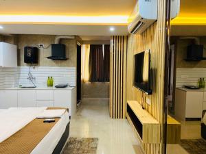 a small room with a bed and a kitchen at The Warmwood Studio in Dehradun