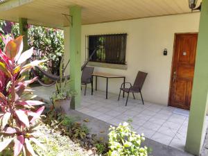a patio with a table and chairs on a house at Cahuita Lodge in Cahuita