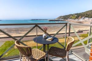 a table and chairs on a balcony with a view of the beach at Hôtel de la Plage in Erquy
