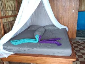a bed in a tent with two people laying on it at Cozzy Saukabu Homestay in Fam