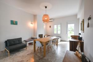 a living room with a dining room table and a couch at Palataki in Epanomi