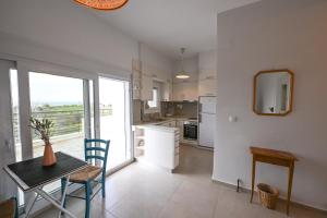 a kitchen and dining room with a table and a window at Palataki in Epanomi +49 photos