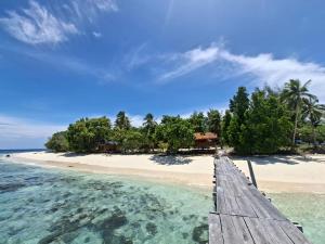 a dock in the water next to a beach at Cozzy Saukabu Homestay in Fam +19 photos