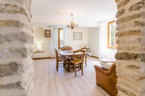 a dining room with a table and chairs and a stone wall at Les pinsons in Parques