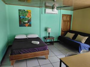 a bedroom with a bed and a couch in a room at Cahuita Lodge in Cahuita