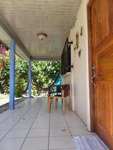 a porch with a wooden door and a chair at Cahuita Lodge in Cahuita