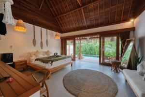 a bedroom in a villa with a bed and a table at Bayrin Private Villas in Nusa Penida +73 photos