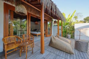 a porch of a villa with a bed and chairs at Bayrin Private Villas in Nusa Penida