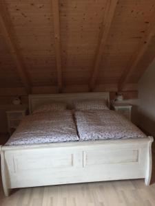 una cama en una habitación con techo de madera en Artgerecht Ferienhäuser, en Bad Berleburg
