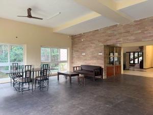 a living room with a piano and a table and chairs at The Temple Tree Residence in Yelagiri