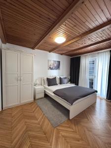 a bedroom with a large bed and a wooden ceiling at Apartments Vukovic in Selce