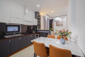 a kitchen with a table and chairs and a sink at Hanami Residence - Self Check-in Accommodation in Danang