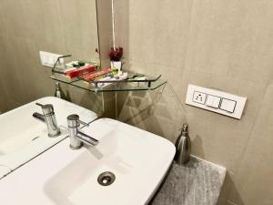 a bathroom with a white sink and a mirror at AtulyaNeer Lakeview Cottage in Kanatal