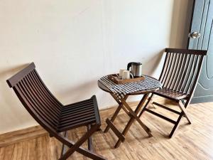 two chairs and a table with a coffee maker on it at AtulyaNeer Lakeview Cottage in Kanatal +6 photos