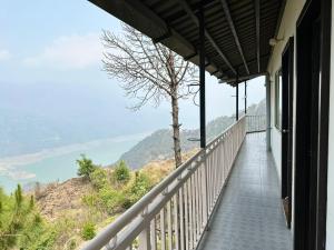 a balcony of a house with a view of the mountains at AtulyaNeer Lakeview Cottage in Kanatal