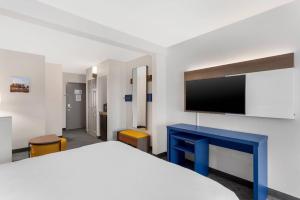 a hotel room with a bed and a tv at Comfort Inn & Suites Suwanee - Sugarloaf in Suwanee