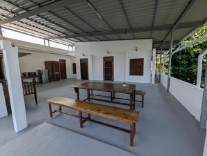 a patio with a wooden table and a bench at Clouthy Villa in Cochin