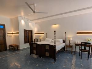 a bedroom with a bed and a table and chairs at Clouthy Villa in Cochin