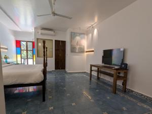 a bedroom with a bed and a television on a table at Clouthy Villa in Cochin