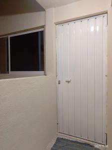 a bedroom with a door and a window at Apartamento Turiksa in Acapulco