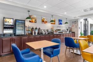 a restaurant with tables and chairs and a bar at Comfort Inn & Suites Suwanee - Sugarloaf in Suwanee