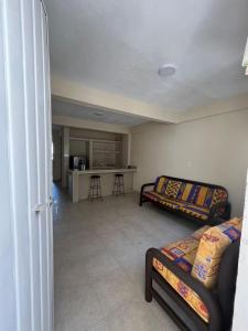 a living room with a couch and a kitchen at Apartamento Turiksa in Acapulco