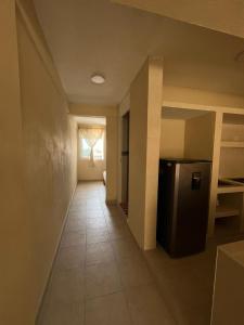 a hallway of a house with a refrigerator and a window at Apartamento Turiksa in Acapulco