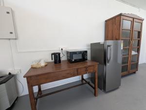 a kitchen with a wooden table with a refrigerator at Clouthy Villa in Cochin