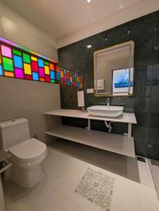 a bathroom with a toilet and a sink and a mirror at Clouthy Villa in Cochin +9 photos